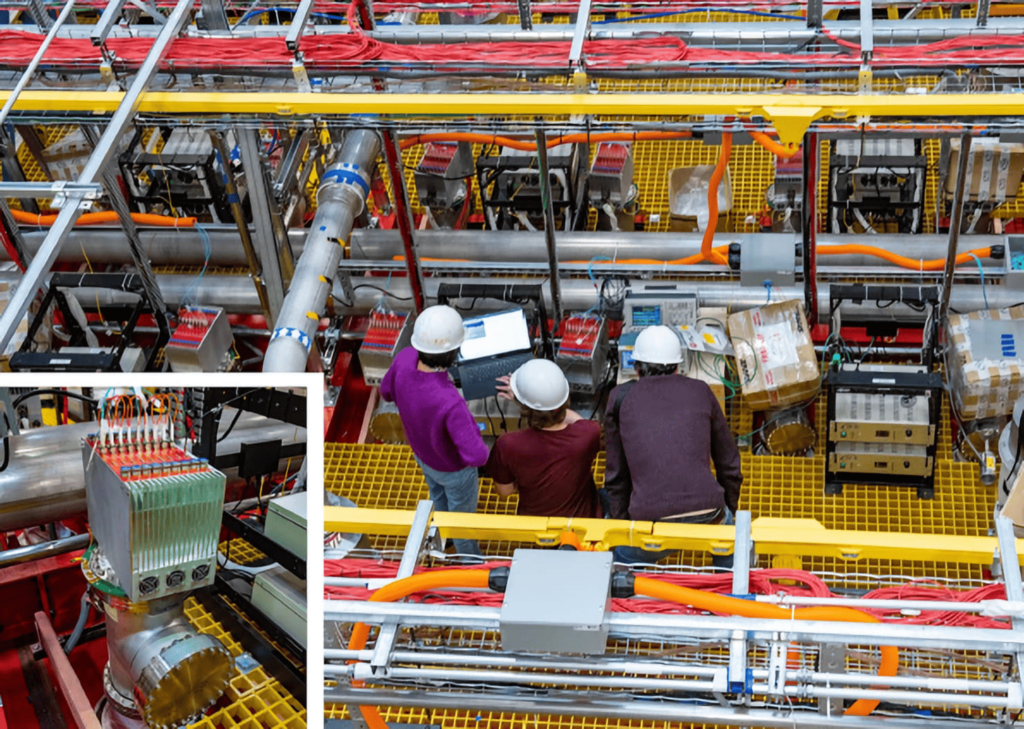 Workers stand on the platform above the ICARUS detector while installing some final components. © Fermi National Accelerator Laboratory.